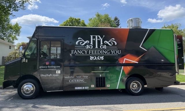 Black food truck with artwork and logo for Fancy Feeding You caterer