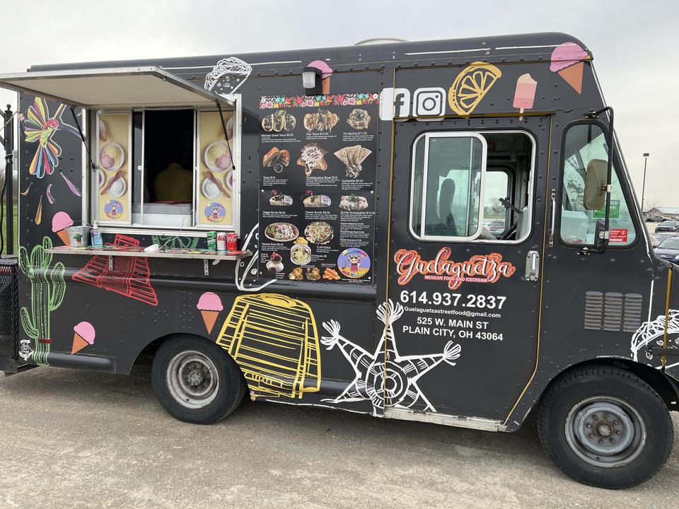 Image depicts food truck with visual menu and company name for Guelaguetza Street Food